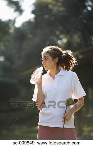 Female golfer taking a drink break View Large Photo Image Stock Photo - Female golfer taking a drink break. Fotosearch