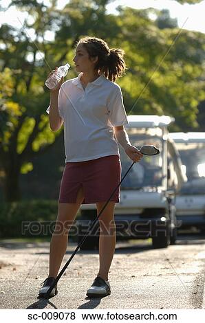 Female golfer taking a drinks break View Large Photo Image Stock Photo - Female golfer taking a drinks break. Fotosearch