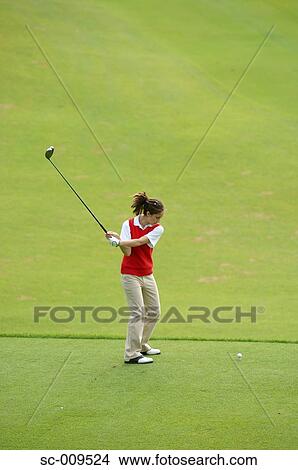 Female golfer taking a swing on the tee ground View Large Photo Image Picture - Female golfer taking a swing on the tee ground. Fotosearch