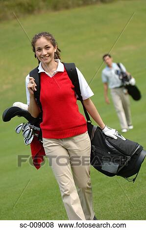 Female golfer walking down the fairway View Large Photo Image Stock Photo - Female golfer walking down the fairway. Fotosearch