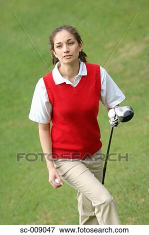 Female golfer walking to the tee ground holding a golf club and a ball View Large Photo Image Stock Photo - Female golfer walking to the tee ground holding a golf club and a ball. Fotosearch