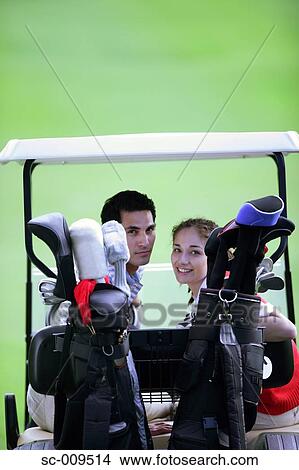 Picture - Golfing couple smiling at the camera. Fotosearch