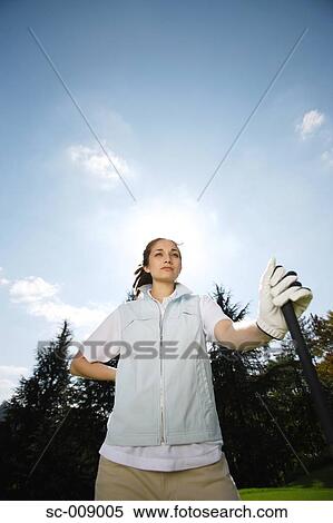 Stock Photography - Low angle view of a female golfer on a sunny day. Fotosearch