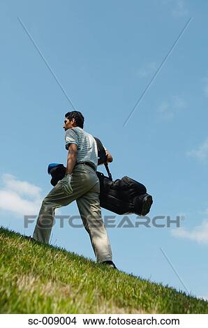 Picture - Male golfer walking purposefully. Fotosearch