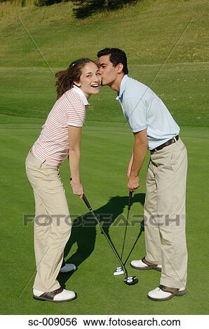 Stock Photograph - Man kissing his golf partner on the cheek. Fotosearch