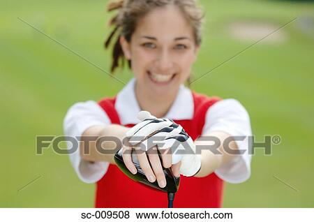 Stock Photo - Portrait of a female golfer holding a golf club. Fotosearch