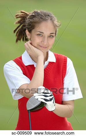 Stock Photo - Portrait of a female golfer holding a golf club. Fotosearch