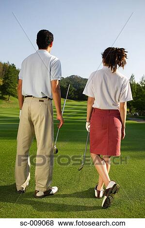 Stock Photo - Rear view of a couple viewing the golf course. Fotosearch