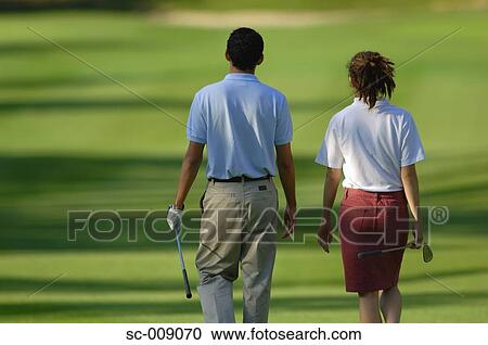 Rear view of a couple walking down the fairway View Large Photo Image Stock Image - Rear view of a couple walking down the fairway. Fotosearch