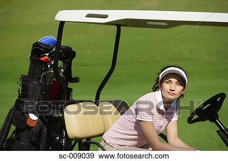 Side view of a woman sitting in a golf cart View Large Photo Image Stock Photo - Side view of a woman sitting in a golf cart. Fotosearch