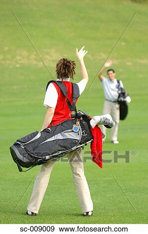 Stock Photo - Two golfers greeting each other on the fairway. Fotosearch