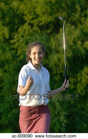 Stock Image - Woman clenching her fist after making a winning putt. Fotosearch