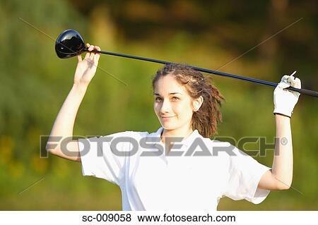 Stock Photo - Woman posing in front of the camera balancing a golf club on her head. Fotosearch