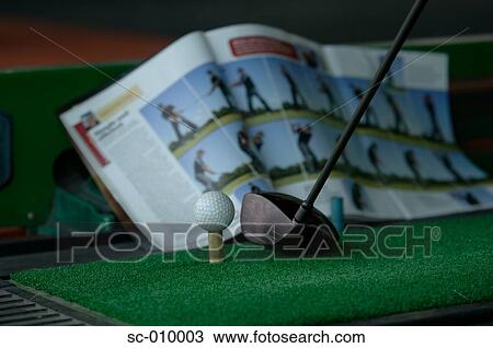Stock Image - Close up of a golf ball, a golf club and a golf magazine. Fotosearch