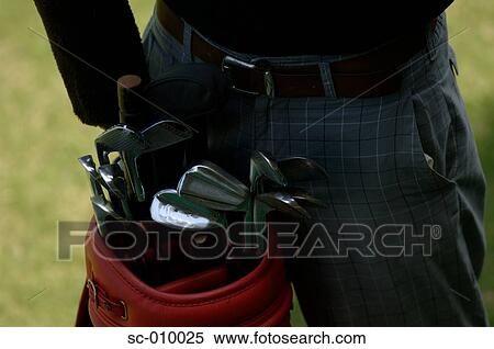 Close up of a golf clubs in a golf bag near a man View Large Photo Image Stock Photography - Close up of a golf clubs in a golf bag near a man. Fotosearch