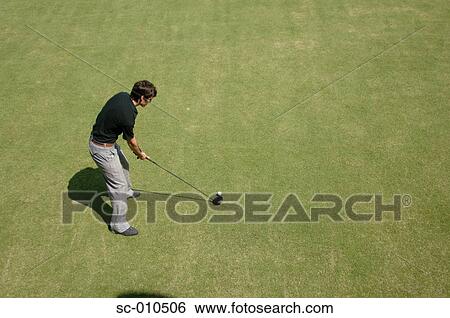 Stock Photograph - High angle view of a man playing a golf shot. Fotosearch