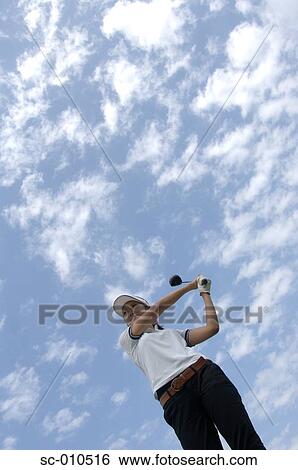 Stock Photograph - High angle view of a woman playing a golf stroke. Fotosearch