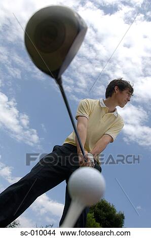 Low angle view of a man playing a golf shot View Large Photo Image Picture - Low angle view of a man playing a golf shot. Fotosearch