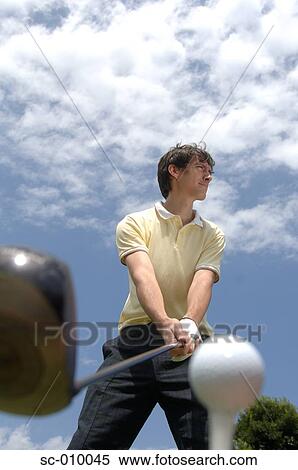 Stock Photography - Low angle view of a man playing a golf shot. Fotosearch