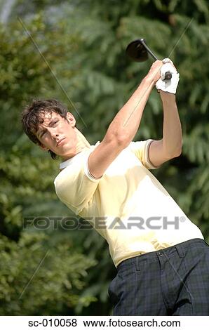 Stock Photo - Portrait of a man playing a golf stroke. Fotosearch