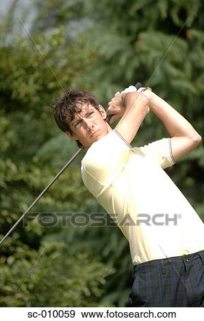Stock Photo - Portrait of a man playing a golf stroke. Fotosearch