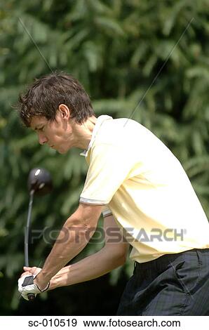 Stock Photo - Portrait of a man playing a golf stroke. Fotosearch