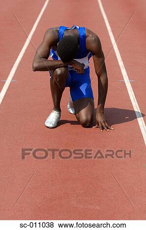 A Tired Male Runner Slumped Over on a Track View Large Photo Image Stock Photo - A Tired Male Runner Slumped Over on a Track. Fotosearch