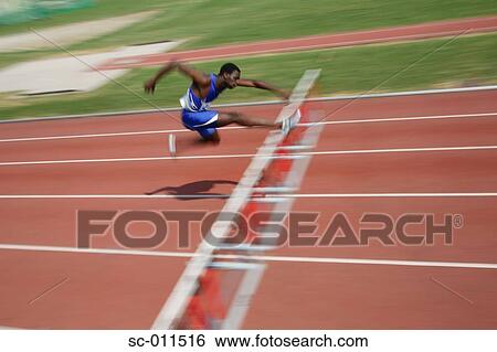 Stock Photograph - Male Runner Clearing a Hurdle. Fotosearch