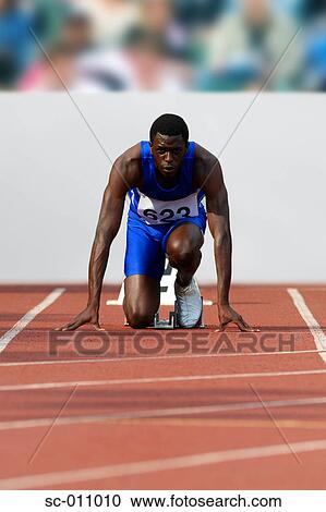 Stock Image - Male Runner Crouched On Starting Blocks. Fotosearch