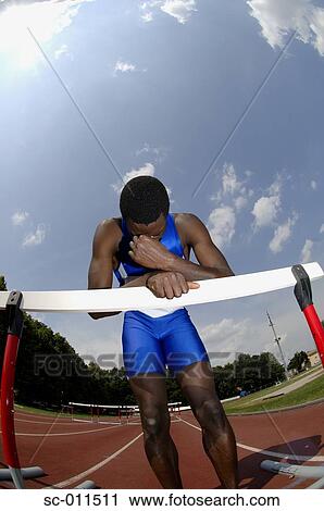Male Runner Leaning Against a Hurdle View Large Photo Image Stock Image - Male Runner Leaning Against a Hurdle. Fotosearch