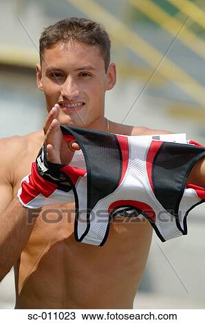Stock Image - Male Runner Putting on His Shirt. Fotosearch