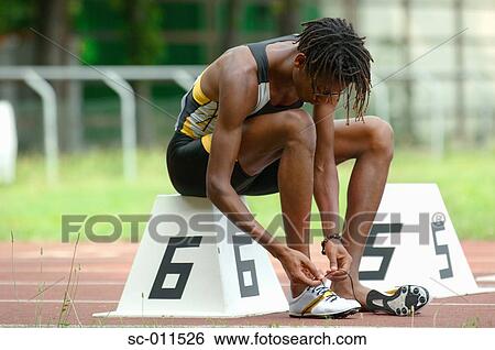 Stock Photograph - Male Runner Tying His Shoes. Fotosearch