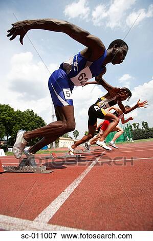 Stock Photo - Male Runners Leaping Off Starting Blocks. Fotosearch