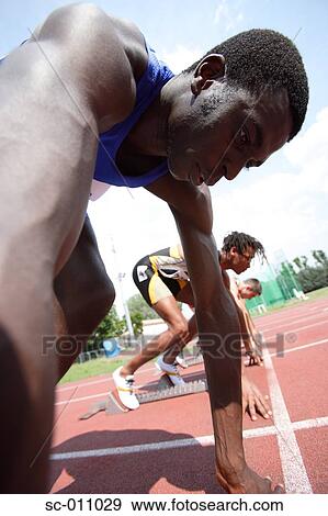 Stock Photo - Male Runners Lined Up on Starting Blocks. Fotosearch