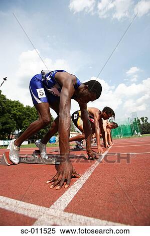 Stock Photography - Male Runners Lined Up on Starting Blocks. Fotosearch