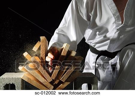 Stock Image - Blackbelt Breaking a Stack of Boards. Fotosearch