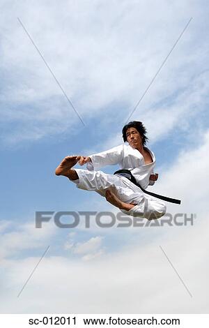 Stock Image - Blackbelt Doing a Flying Kick. Fotosearch
