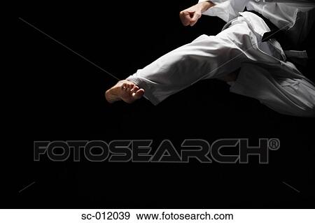 Stock Photo - Blackbelt Doing a Flying Kick. Fotosearch