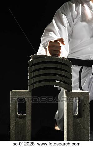 Stock Photo - Blackbelt Preparing to Break a Stack of Concrete Blocks. Fotosearch