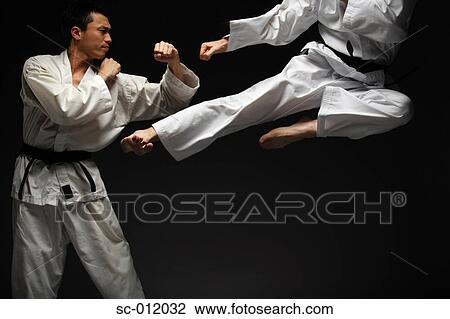 Stock Image - Two Blackbelts Sparring. Fotosearch