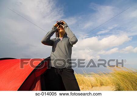 Stock Photography - Camper looking through binoculars. Fotosearch