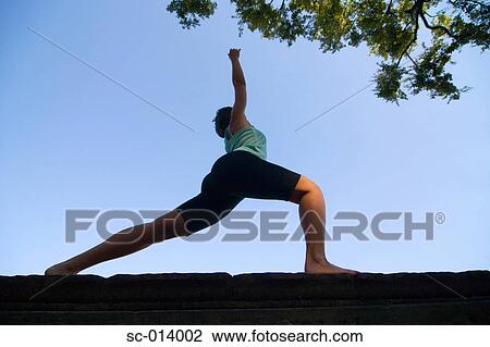Silhouetted young woman exercising View Large Photo Image Stock Image - Silhouetted young woman exercising. Fotosearch