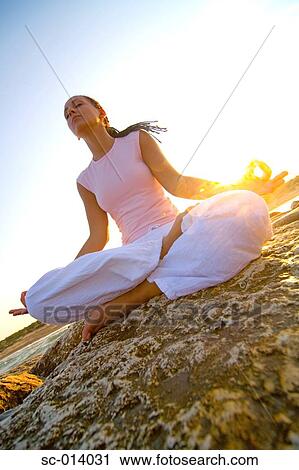 Stock Image - Young woman doing yoga exercises. Fotosearch