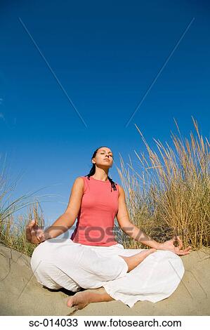 Stock Image - Young woman doing yoga exercises. Fotosearch