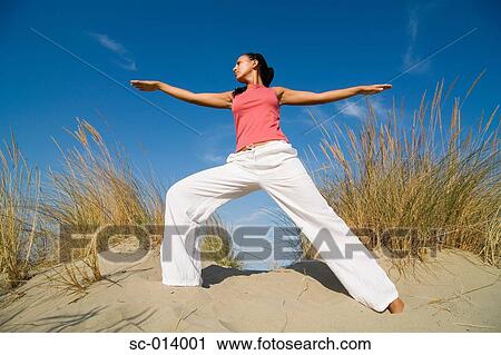 Young woman exercising on sand dune View Large Photo Image Stock Image - Young woman exercising on sand dune. Fotosearch