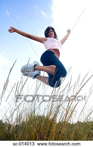 Young woman jumping View Large Photo Image Stock Image - Young woman jumping. Fotosearch