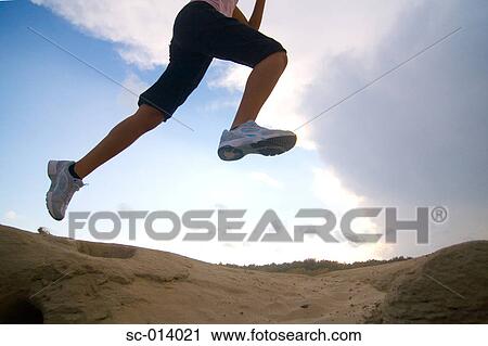 Stock Image - Young woman jumping. Fotosearch