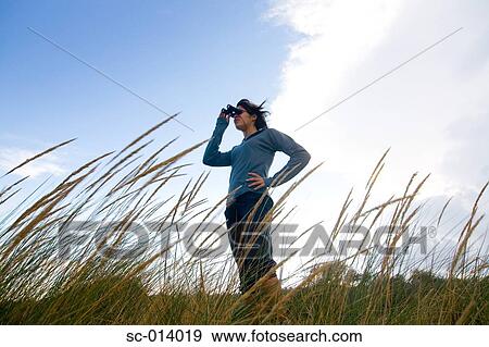 Young woman looking through binoculars View Large Photo Image Stock Photo - Young woman looking through binoculars. Fotosearch