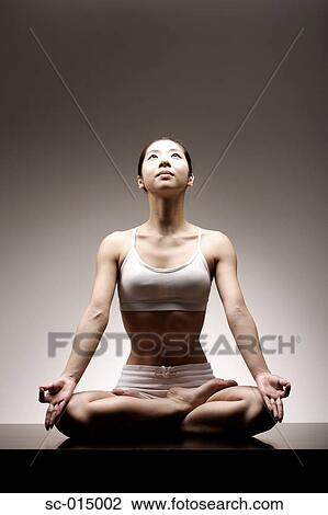 Stock Image - Young Asian woman in lotus position. Fotosearch