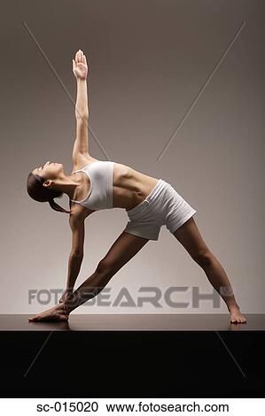 Young Asian woman in Triangle Pose yoga position View Large Photo Image Stock Image - Young Asian woman in Triangle Pose yoga position. Fotosearch
